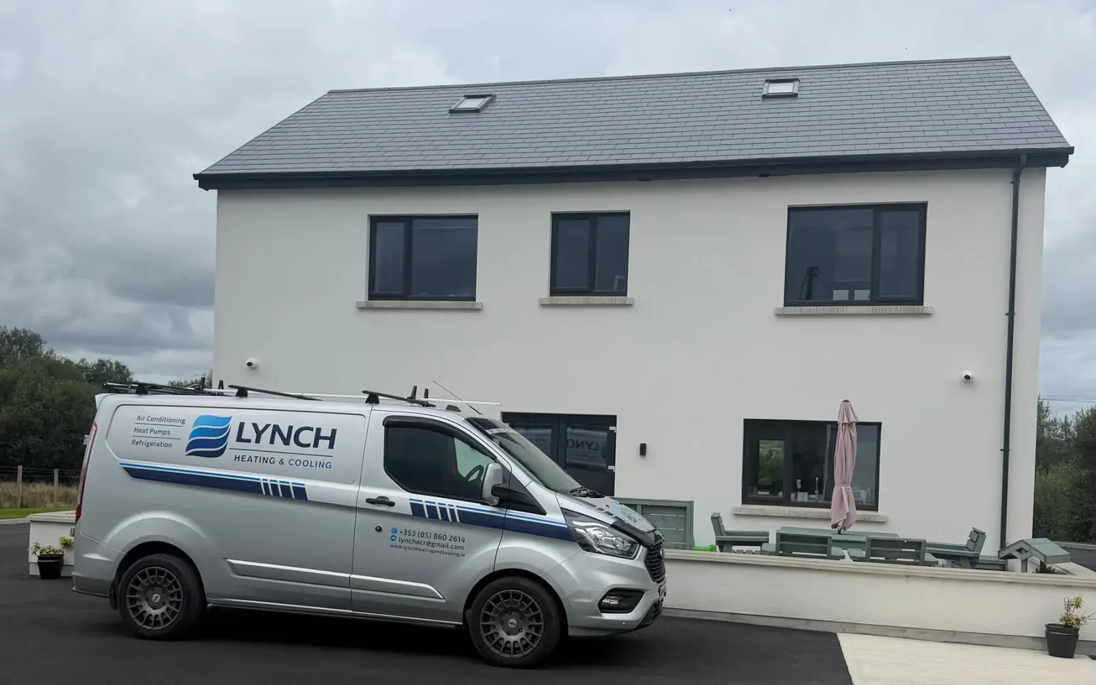 Lynch Heating & Cooling van parked outside a newly built two-storey house